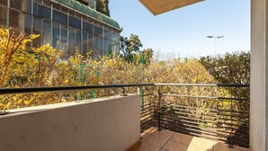 A balcony with a view of a building with large windows and a green roof. - Le Flamboyant du Fonserane - Climatisé (Béziers)