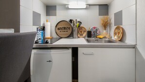 A compact kitchen with a microwave, a sink, and a small refrigerator. - Le Flamboyant du Fonserane - Climatisé (Béziers)