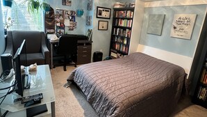 A bedroom with a bed, a desk, a chair, a ceiling fan, and a bookshelf. - Room in townhouse (Vancouver)