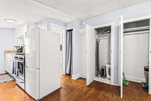 Una cocina moderna con armarios blancos, horno empotrado y refrigerador.