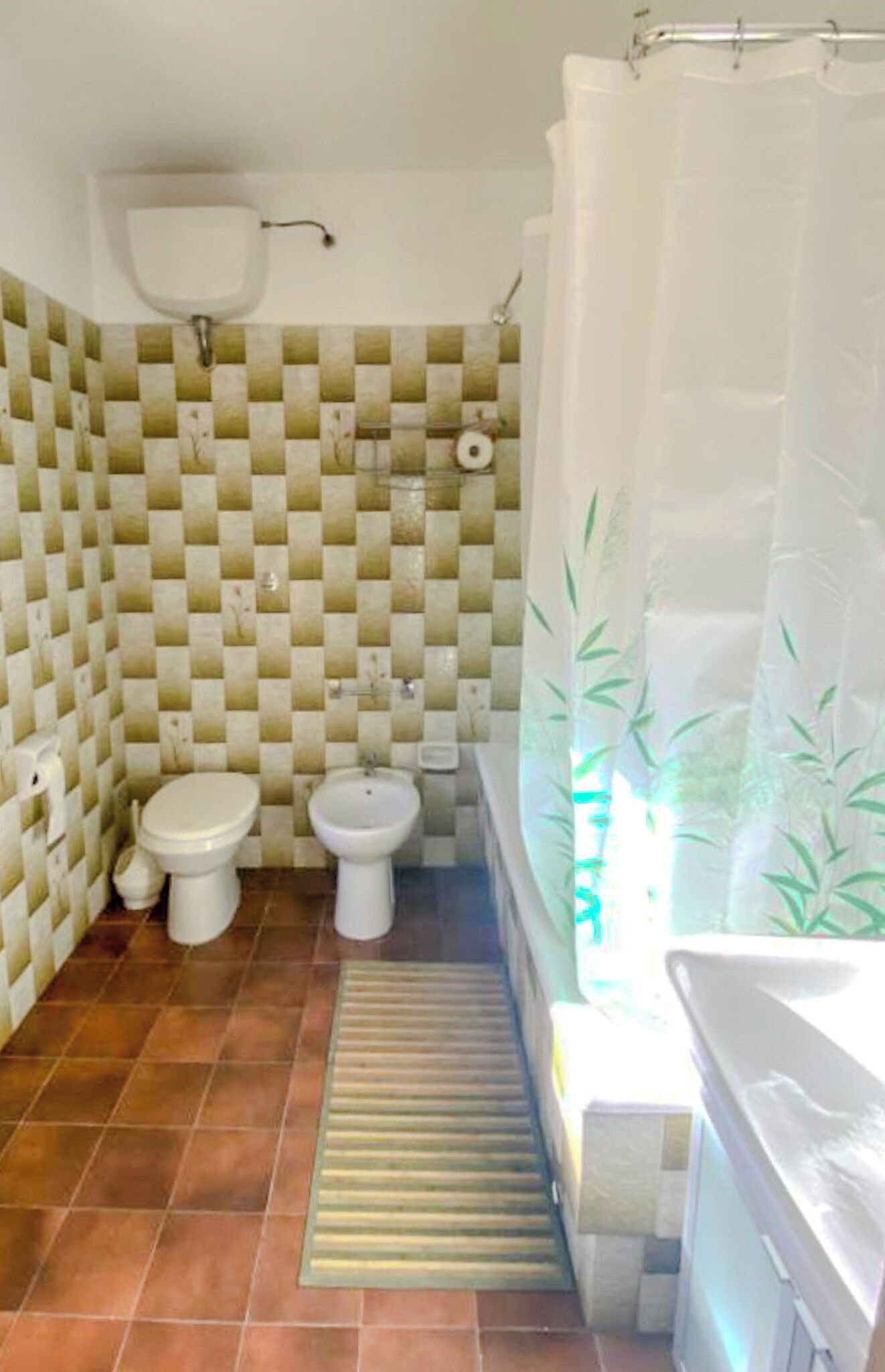 Un bany petit amb vàter, bidet i banyera.