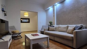 Ein modernes Wohnzimmer mit einer Couch, einem Couchtisch und einem Fernseher.