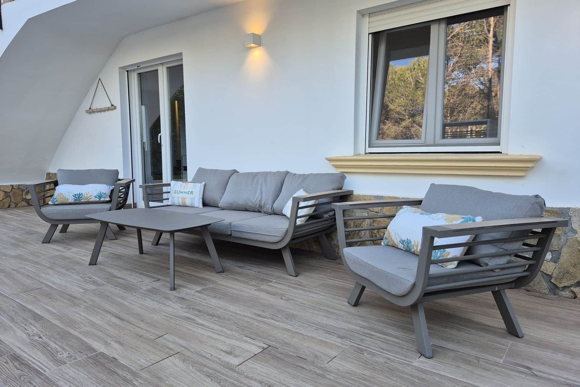 Une terrasse avec un canapé, des chaises et une table.