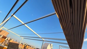 Ein modernes Gebäude, durch dessen offene Struktur ein klarer, blauer Himmel sichtbar ist.