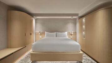 Un dormitorio moderno con una cama grande, armarios empotrados e iluminación empotrada en el techo.