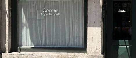 Entrada de un edificio con un cartel que dice "Corner Apartments".