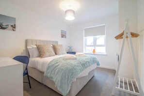 A bedroom with a bed, a desk, a chair, a window, and a white ladder. - Lendrick House - 3 bed house with parking, Falkirk (Falkirk)
