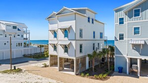 A beachfront multi-story building with a pool, a covered patio, and a view of the ocean. - Honeydew: Beautiful Beachfront Home with Private Pool and Pets Welcome! (Mexico Beach)