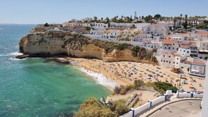 A coastal town with a beach, buildings, and cliffs. - "Ocean View Terrace", The best sea view - directly on the beach of Carvoeiro (Carvoeiro)