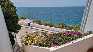 A balcony with a view of the sea, a flower bed, and a tiled floor. - "Ocean View Terrace", The best sea view - directly on the beach of Carvoeiro (Carvoeiro)
