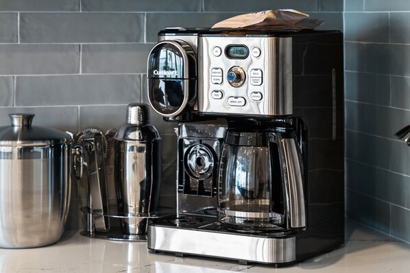A coffee maker with a digital display, control buttons, and a coffee pod holder.