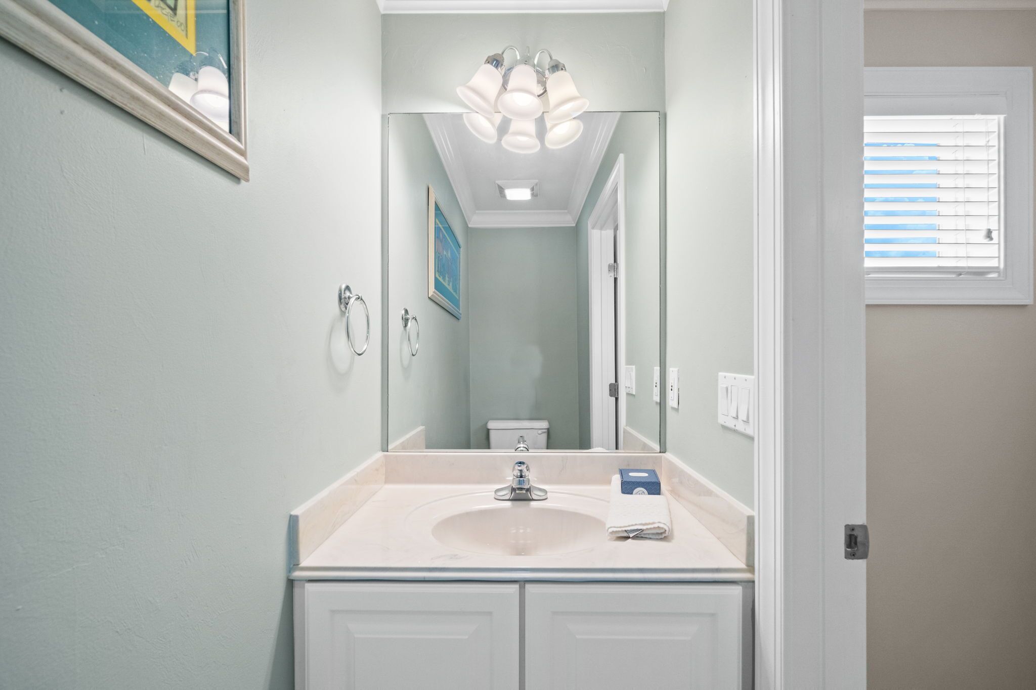 A bathroom with a sink, mirror, and a ceiling light fixture.
