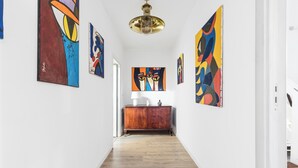 Ein Flur mit Holzboden, weißer Wand und Holzschrank.