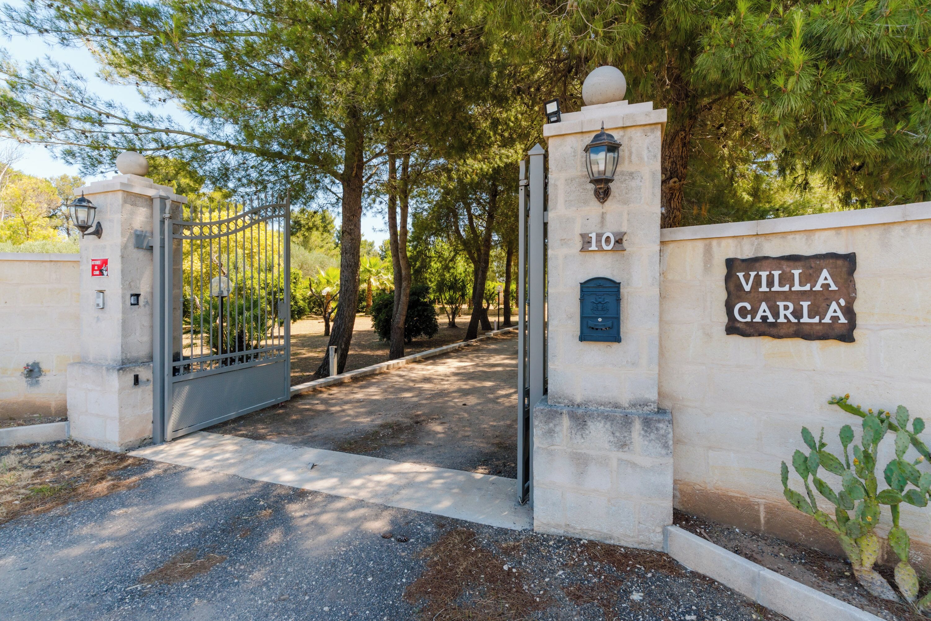 A gated entrance with a sign reading "Villa Carla" and a number "10" on a wall.