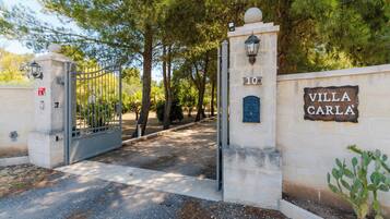 Un cancello con un cartello che riporta 'Villa Carla' e il numero '10' su un muro.