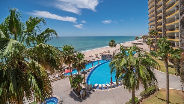 Un resort con piscina, playa y vista al océano.