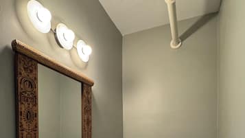 A bathroom with a white sink, a toilet, and a mirror with ornate detailing.