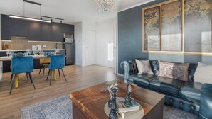 A modern living room with a leather sofa, a wooden coffee table, and a chandelier.
