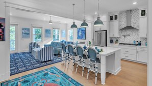 A modern kitchen with white cabinetry, a central island, and pendant lighting. - Blue Water Paradise! NEW PRIVATE POOL! 6-bdrm near beaches, restaurants, 8 bikes (Santa Rosa Beach)