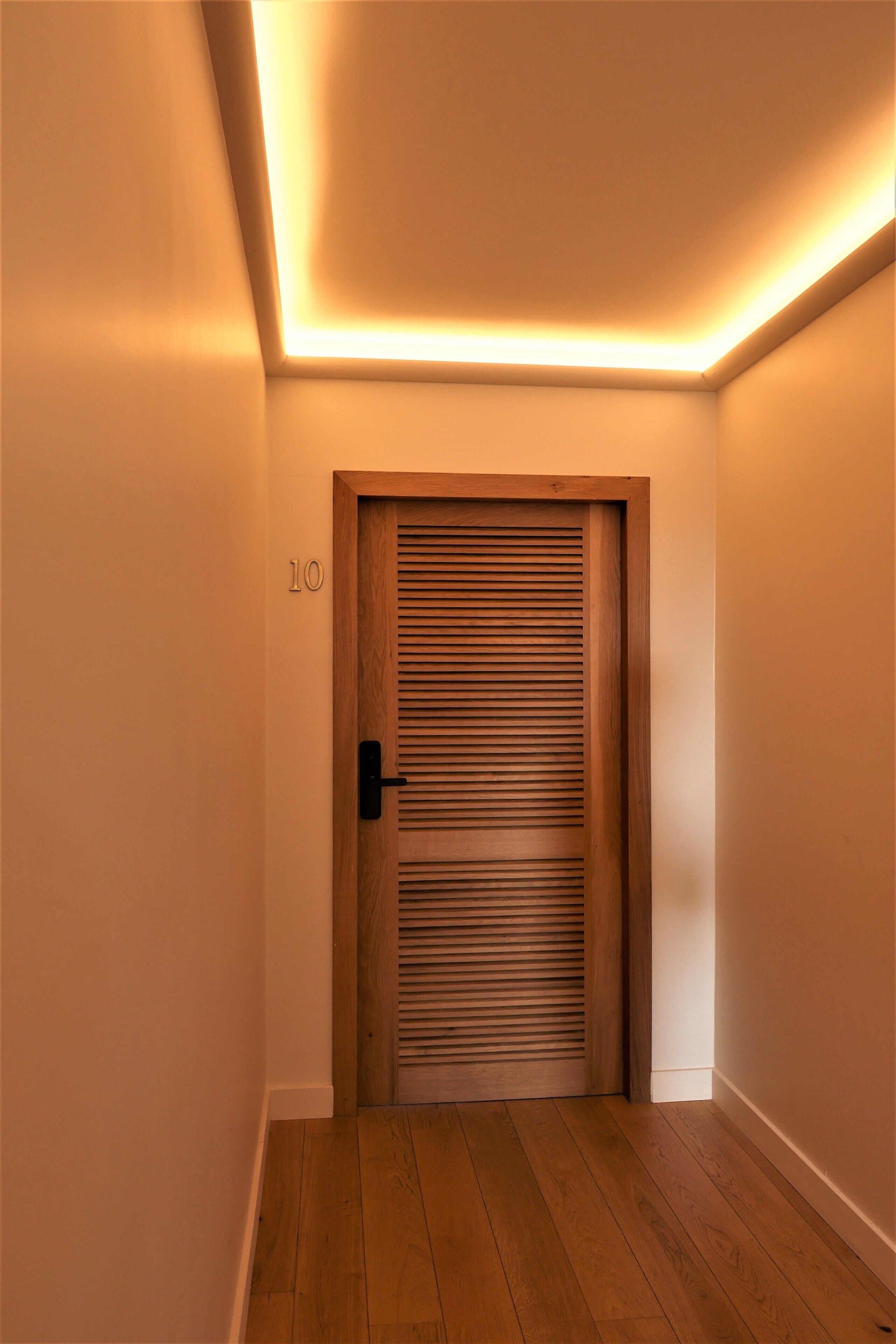 Un pasillo con una puerta de madera marcada con el número 10, que da a una habitación.