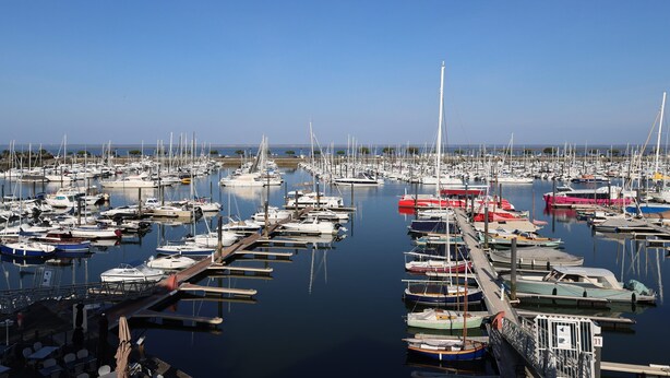 Un puerto deportivo con numerosos barcos amarrados en varios muelles.