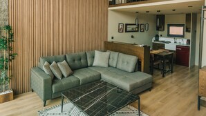 A modern living room with a sectional sofa, a coffee table, and a wooden slatted wall. - Casa Vera Villa (Sapanca)