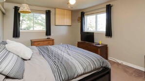 A bedroom with a bed, a nightstand, a dresser, a ceiling fan, and a TV. - Cottage on Georgian Bay, Severn, Honey Horbour (Port Severn)