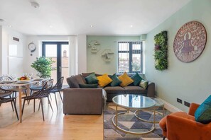 Een moderne woonkamer met een bank, salontafel en een eethoek.