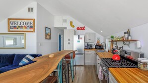 Eine moderne Küche mit Holzarbeitsplatten, einem Herd und einem Essbereich mit einem Holztisch und Stühlen.