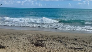 A beach with waves, clear sky, and distant horizon. - Zen Penthouse with Spectacular Ocean and Nature Reserve Views for Family Retreat (Medianía Alta Loiza)