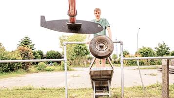A person standing next to a mechanical device outdoors.