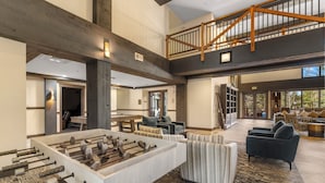 A spacious living area with a foosball table, comfortable seating, a staircase, and a view of the outdoors. - Sp8865-2 (Keystone)