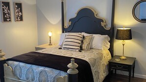 A bedroom with a bed, a ceiling fan, two bedside lamps, a nightstand, and a mirror on the wall. - Long term chic en suite 2 bedroom Corp Rental in N. Knox/Powell with WiFi, AC (Powell)