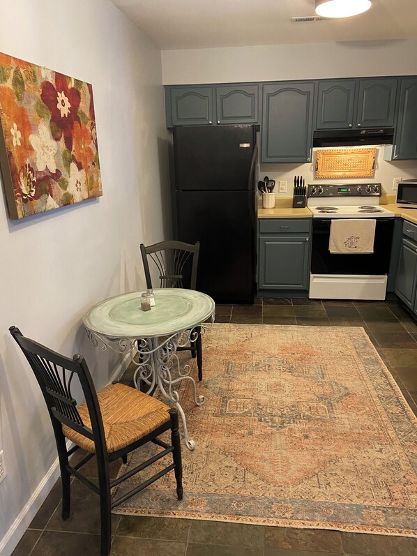 A kitchen with a dining table, chairs, a refrigerator, stove, and cabinets. - Long term chic en suite 2 bedroom Corp Rental in N. Knox/Powell with WiFi, AC (Powell)