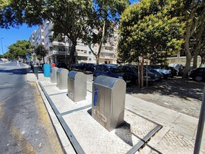 A street with parked cars, a sidewalk, and mailbox posts.