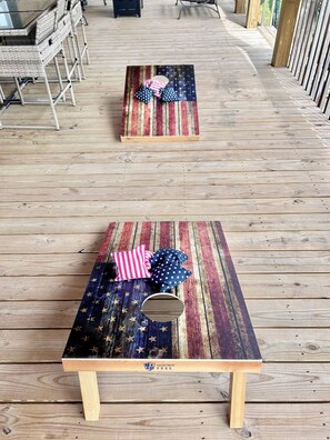 Two outdoor wooden tables with star-patterned tablecloths and pillows, set on a wooden deck. - Elegant Retreat • King Bed • Expansive Deck • Peaceful Escape •  Fireplace (Crossville)