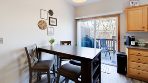 A dining area with a table and chairs, a small plant, and a wall with framed pictures. - 2 Kings, Workspace, Garage 3bdrm - Pastore`s Place (Manhattan)
