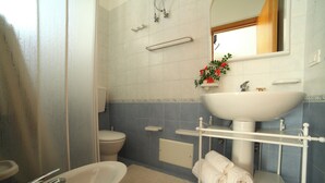 Ein Badezimmer mit Badewanne, Toilette, Waschbecken und Handtuchhalter.