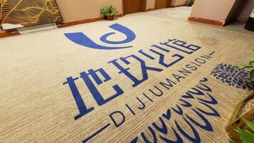 Entrada de hotel con felpudo que muestra el nombre "DIJUMANSION" en grandes letras azules.