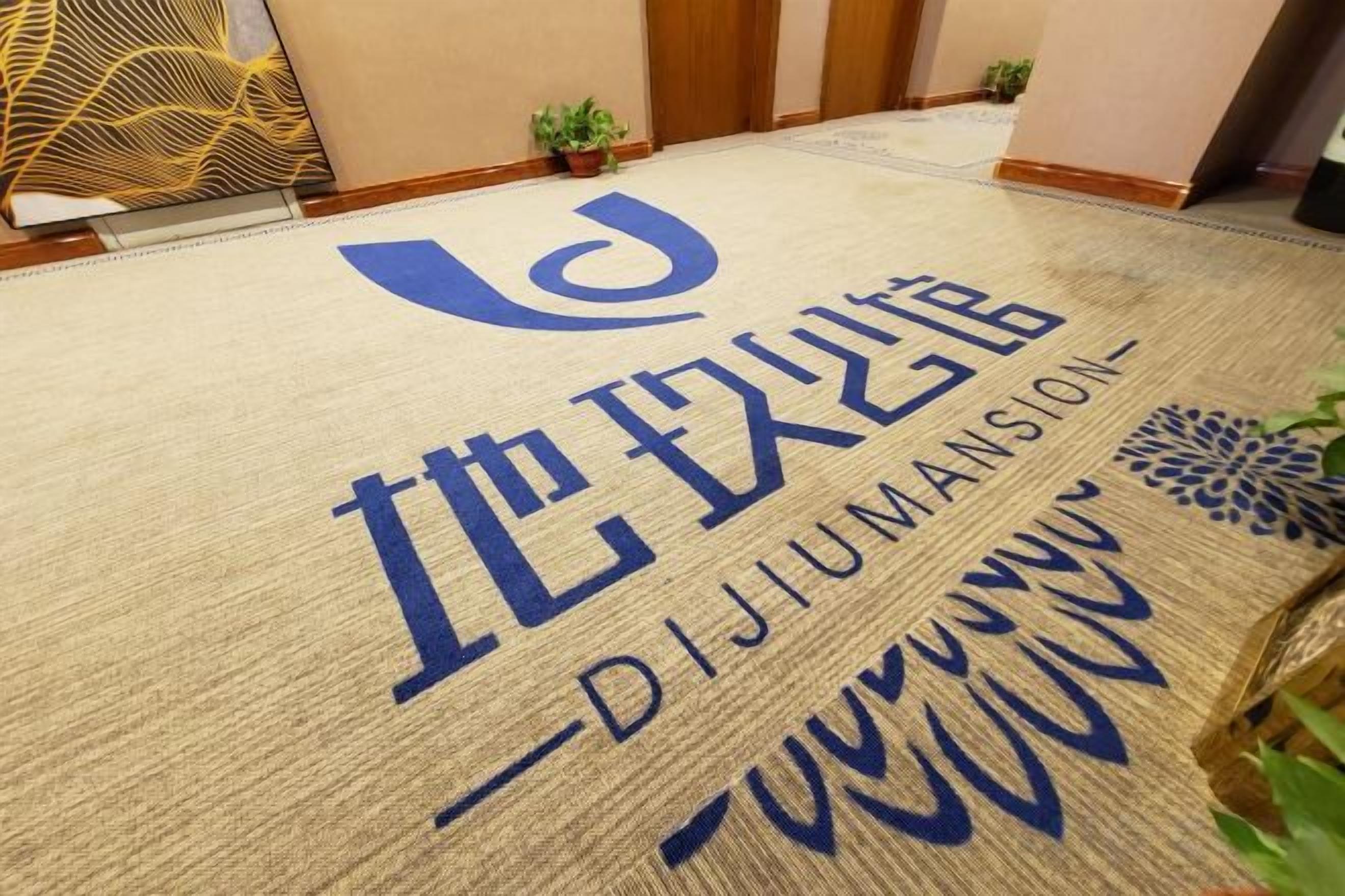 A doormat with the text 'DEJIUMANSION' and a logo.