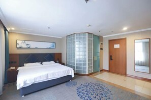 A modern hotel room with a large bed, a decorative glass partition, a wooden door, and a large mirror. - Diyu Mansion Hotel (Harbin Central Street) (Harbin)