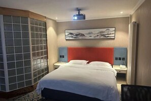 A hotel room with a bed, a nightstand, a projector, and a large window with a view of the mountains. - Diyu Mansion Hotel (Harbin Central Street) (Harbin)
