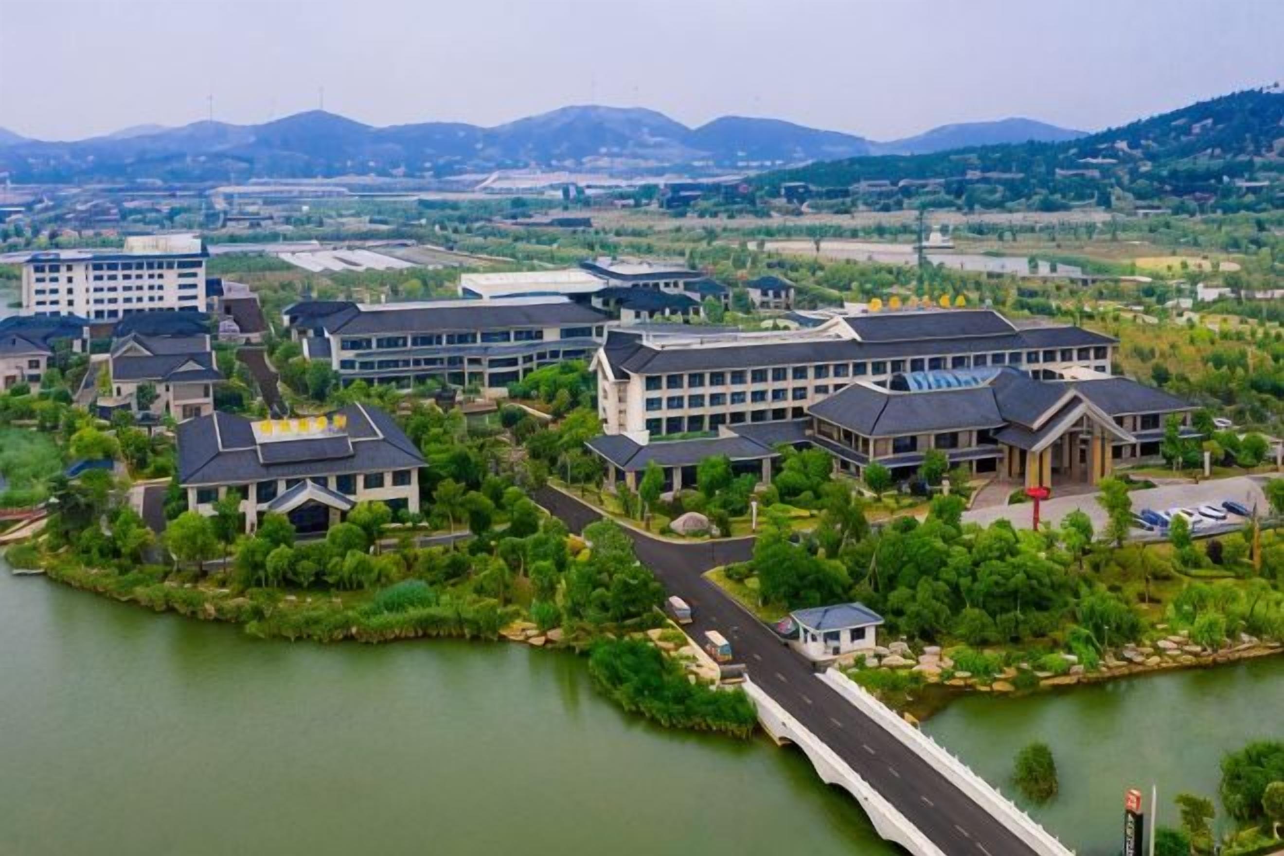 A residential area with multiple buildings, a bridge, and a body of water.