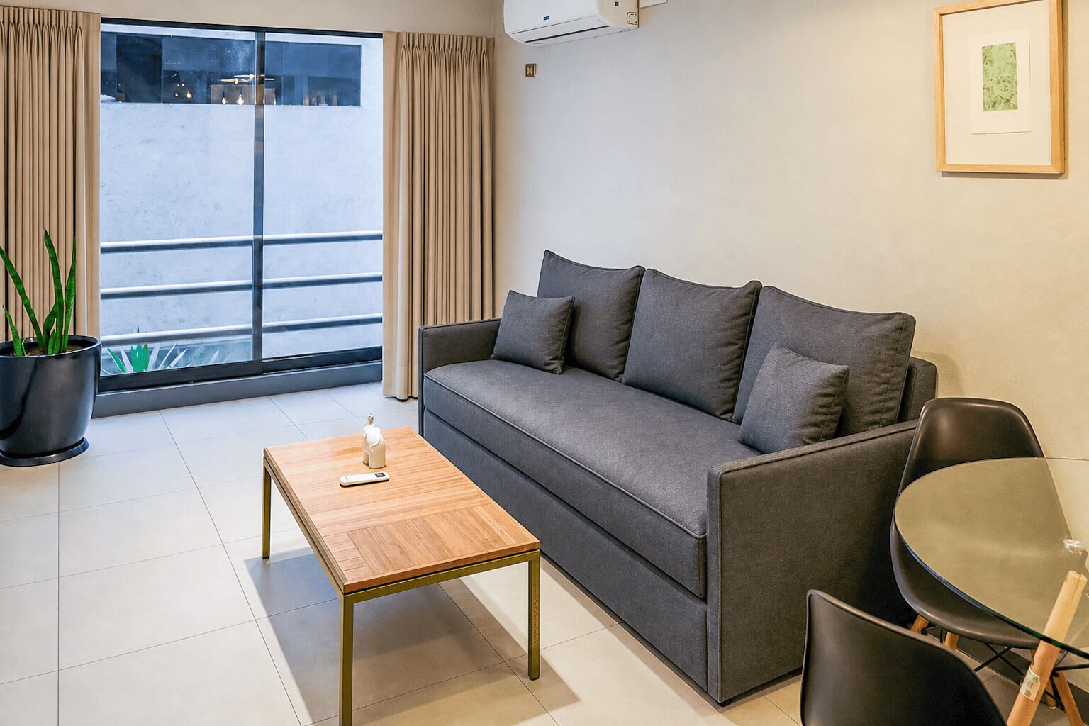 Un salon moderne avec un canapé, une table basse et un coin repas.