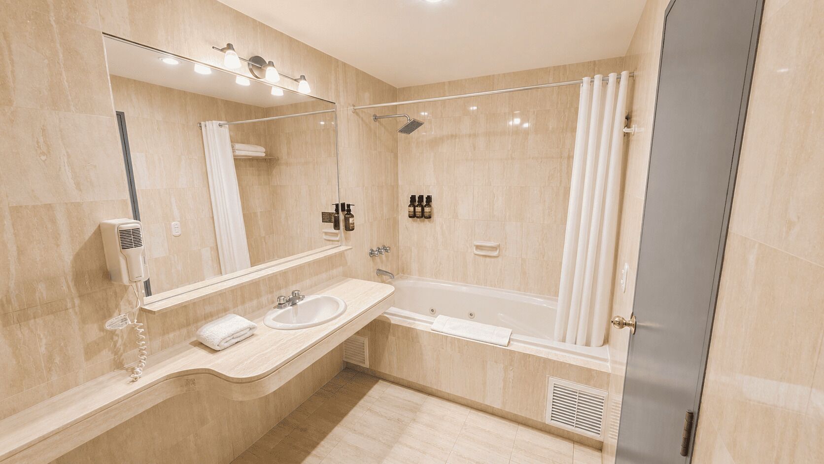 A modern bathroom with a vanity, a bathtub, and a shower.