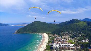 A coastal town with a beach, a marina, and buildings with a mix of architectural styles.