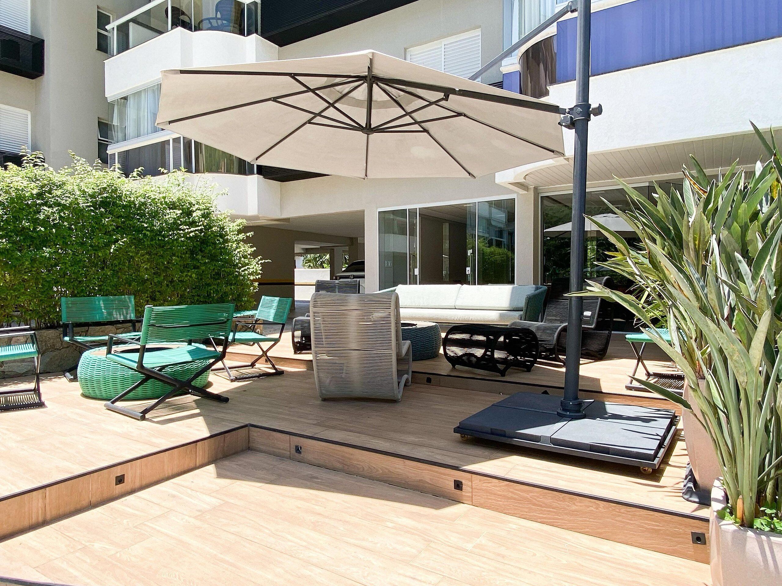 An outdoor patio area with a sofa, chairs, a table, and an umbrella.