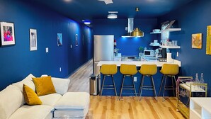 Una cucina moderna con isola centrale, sgabelli da bar e zona pranzo.