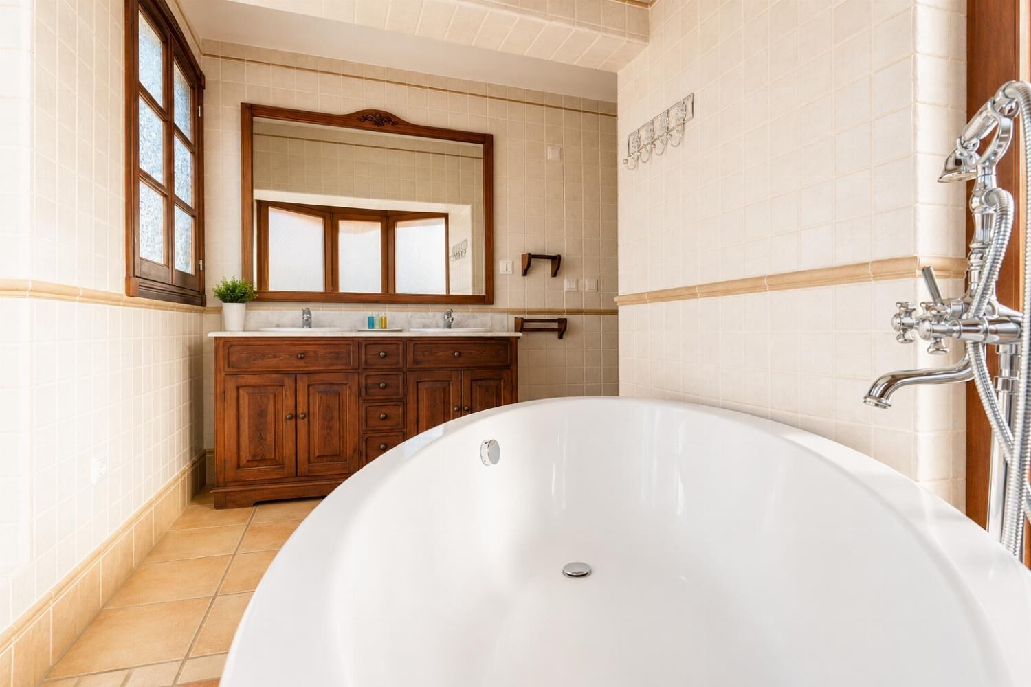 Une salle de bain avec une baignoire sur pieds, un meuble-lavabo en bois et un grand miroir.