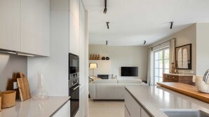 A modern kitchen with a central island, built-in oven, and a large window providing natural light. - Villa Veronika – Stone design villa of tranquility (Vabriga)